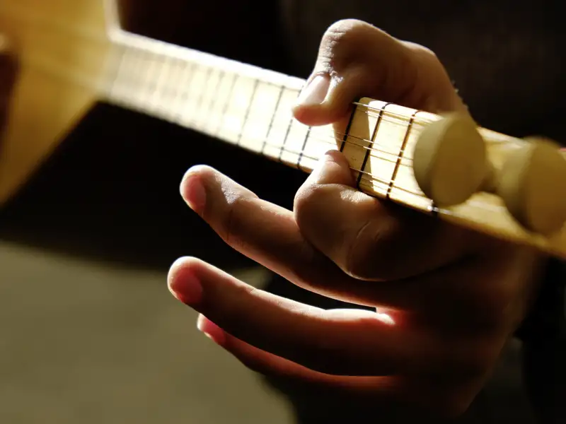 Hände spielen auf dem Griffbrett einer Saz, einer Langhalslaute.