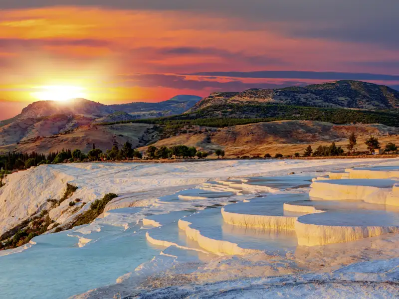 Die Kalksinterterrassen von Pamukkale stehen auf der Route unserer Rundreise durch die Westtürkei von Istanbul bis Antalya. Besonders im Abendlicht schimmert der Kalkstein gülden.