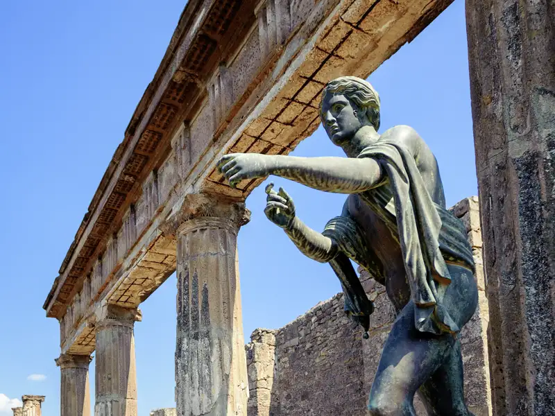 Wir besuchen auf unserer Studienreise am Golf von Neapel Pompeji: Über den Säulen des Forums erhebt sich im Hintergrund der Vesuv.