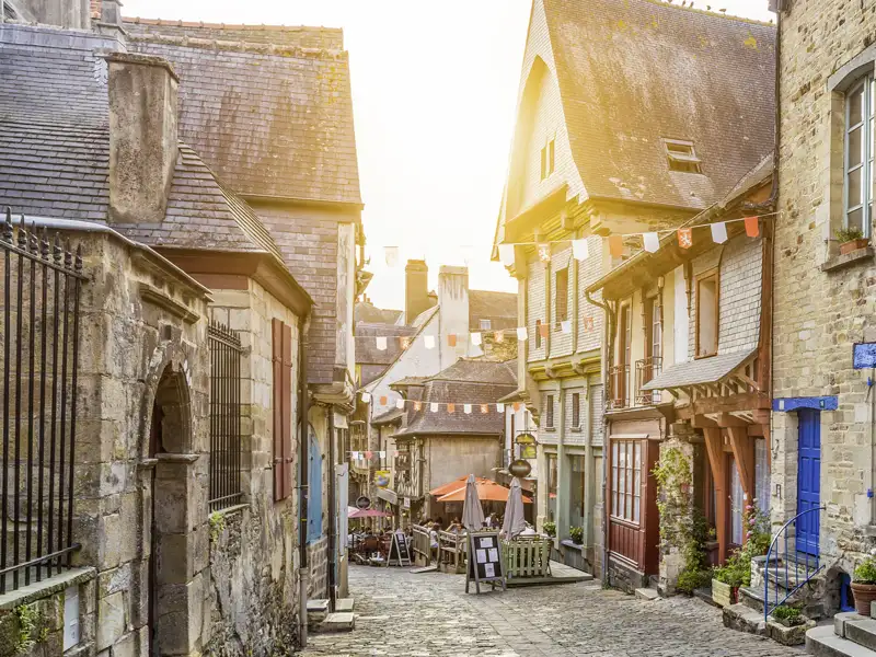 Gepflasterte Straße mit historischen Gebäuden und Straßencafés