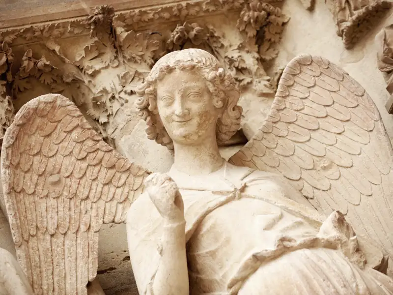 Auf unsererer Studienreise nach Frankreich verbringen wir auch eine Nacht in Reims und haben Gelegenheit, die berühmte Kathedrale, Krönungskirche der französischen Könige, zu besichtigen. An der Fassade entdecken wir manch spannendes Detail wie den oft dargestellten lächelnden Engel.