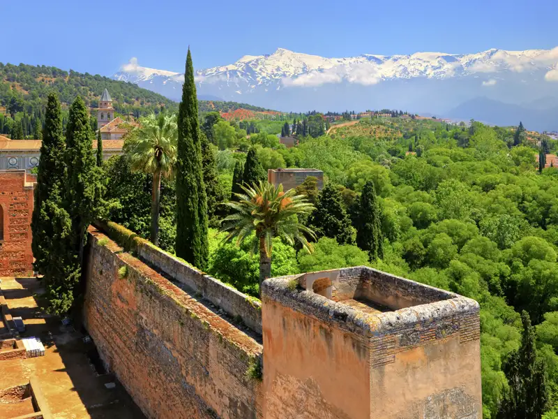 Panoramablick von der Alhambra auf die grüne Umgebung und die schneebedeckten Gipfel der Sierra Nevada