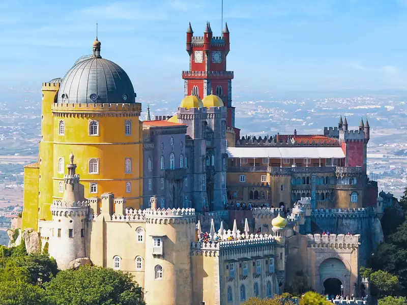 Auf unserer Studienreise zu Portugals Höhepunkten besichtigen wir auch Sintra. Zwar nicht das hier abgebildete Bergschloss Palácio da Pena, früher die Sommerfrische des portugiesischen Königshauses, aber den Nationalpalast im Ort.