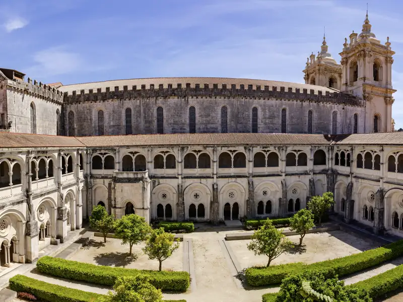 Auf unserer Rundreise durch Portugal besichtigen wir das Kloster Mosteiro da Batalha, ein wichtiges Denkmal der portugiesischen Gotik. Der ruhige Innenhof ist perfekt für den Vortrag ihrer Reiseleiterin.