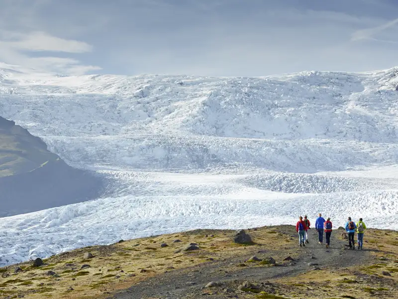 Während der Rundreise mit Studiosus durch Island spazieren wir an der Gletscherlagune Fjallsarlon entlang. Im Hintergrund ist der mächtige Gletscher Vatnajökull zu sehen.