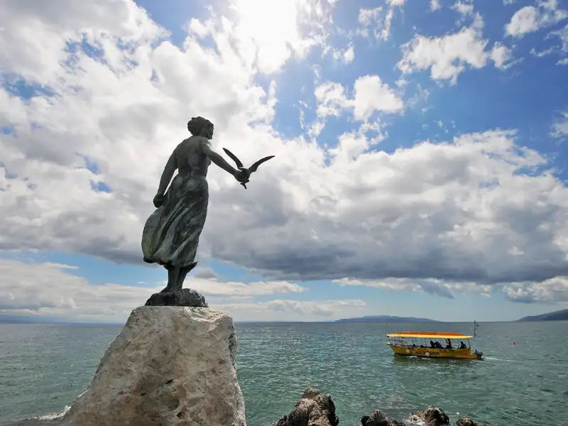 Blicken Sie wie das Mädchen mit der Möwe im kroatischen Opatija auf die blaue Adria hinaus – Urlaubsfeeling auf Ihrer Rundreise!