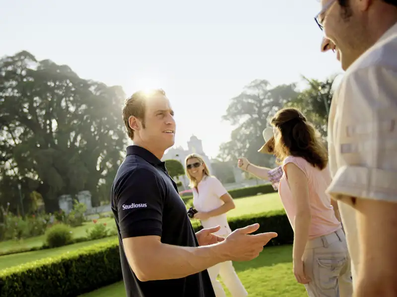 Studiosus-Reiseleiter im Gespräch mit Reiseteilnehmern in einem Park