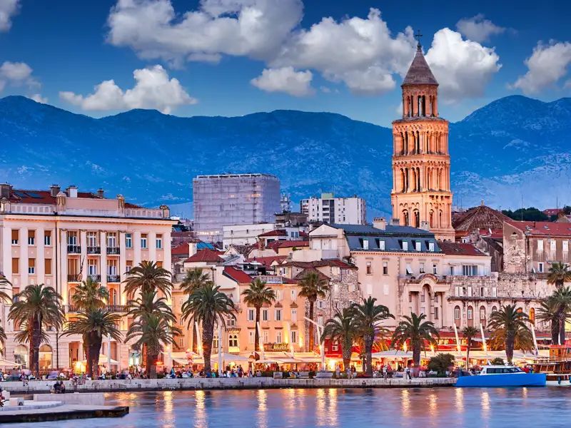 Belebte Uferpromenade von Split in der Abenddämmerung mit Blick auf den Glockenturm des Diokletianpalastes