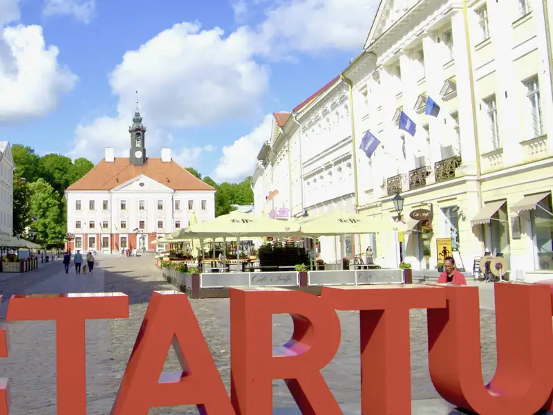 Der Rathausplatz in Tartu mit dem historischen Rathausgebäude und dem modernen STARTUP-Schriftzug, der die aufstrebende Startup-Szene der Stadt symbolisiert.