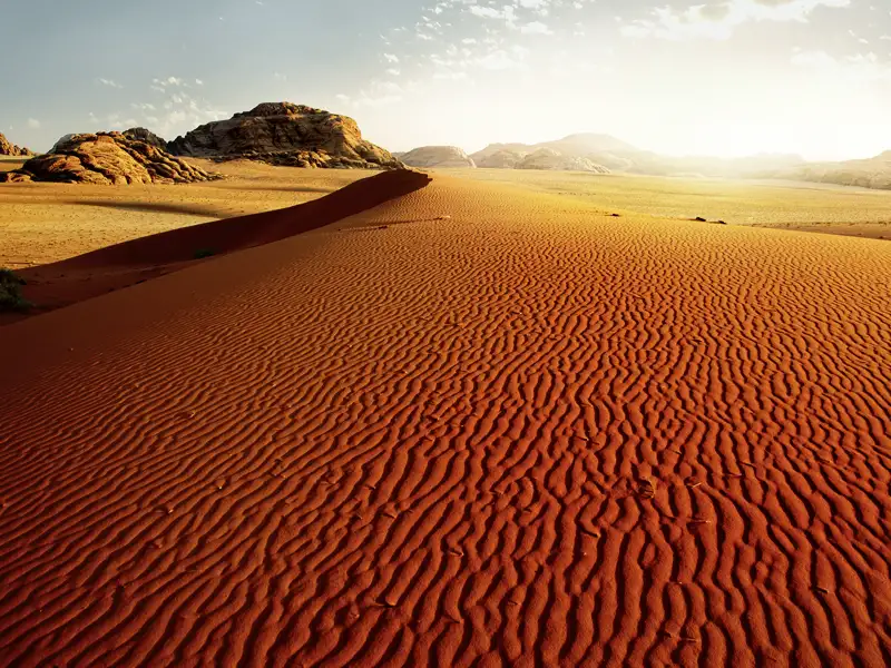 Wüstensand und Wüstenwind - die Destination Wadi Ram auf unserer Reise in kleiner Gruppe durch Jordanien begeistert mit ihrer einzigartigen Aura und magischen Lichtspielen in Orange und Rot.