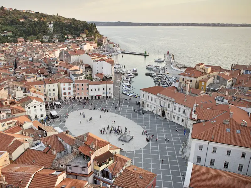 Panoramablick auf den Tartini-Platz, die umliegenden Gebäude und den Hafen von Piran an der slowenischen Küste. Hier beziehen wir Quartier bei der Studienreise im Komfortbus nach Slowenien und Istrien.
