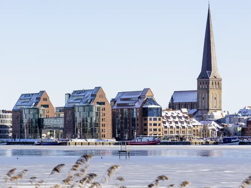 Genießen Sie auf Ihrer Silvesterreise den verschneiten Ausblick auf die Uferpromenade Rostocks.