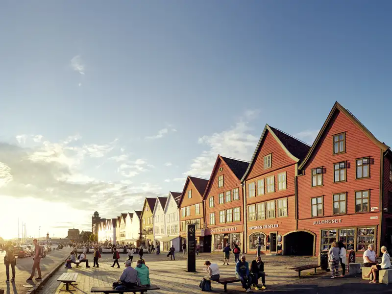 Die bunten Holzhäuser des Hanseviertels Bryggen in Bergen im Abendlicht, eine im Reiseverlauf inkludierte Sehenswürdigkeit, die von der Hansezeit zeugt.