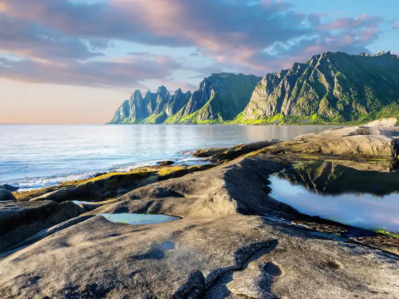 Blick von der felsigen Küste auf die markante Bergkette 'Teufelszähne' auf der Insel Senja. Ein geplanter Stopp beim Fototermin dieser Reise an der Küste von Senja.