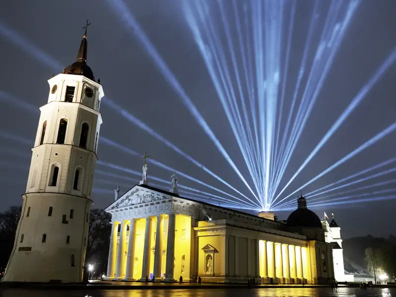 Die Kathedrale von Vilnius und der Glockenturm bei Nacht, beleuchtet von einer Lichtershow, ein Programmpunkt der Reise, der im Reiseverlauf enthalten ist.