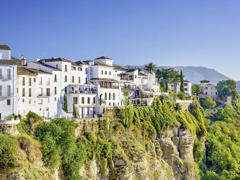 Ansicht der weißen Häuser von Ronda, die auf einer Klippe thronen, ein Programmpunkt der Rundreise, der den Besuch eines 'Weißen Dorfes' vorsieht.