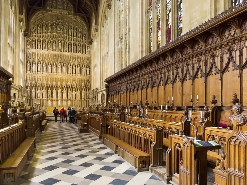 Auf unserer Gruppenreise nach Oxford bewundern wir die Innenansicht einer historischen gotischen Kapelle, mit Fokus auf das kunstvoll geschnitzte Chorgestühl und den Altarbereich. Dies ist ein Highlight auf unserer Städtereise mit Studiosus.