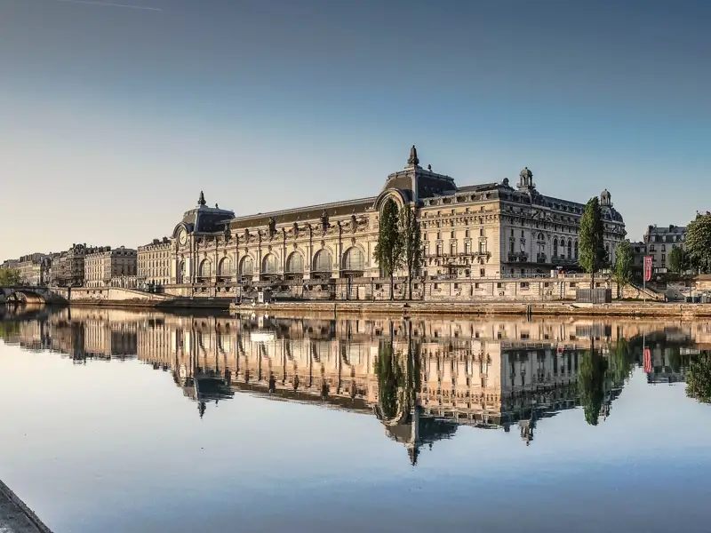 Auf unserer Gruppenreise nach Paris bemerken wir das Gebäude des Musée d'Orsay am Ufer der Seine in Paris. Ein Besuch des Kunstmuseums, um Werke des Impressionismus zu sehen, ist ein Highlight jeder Rundreise mit Studiosus.