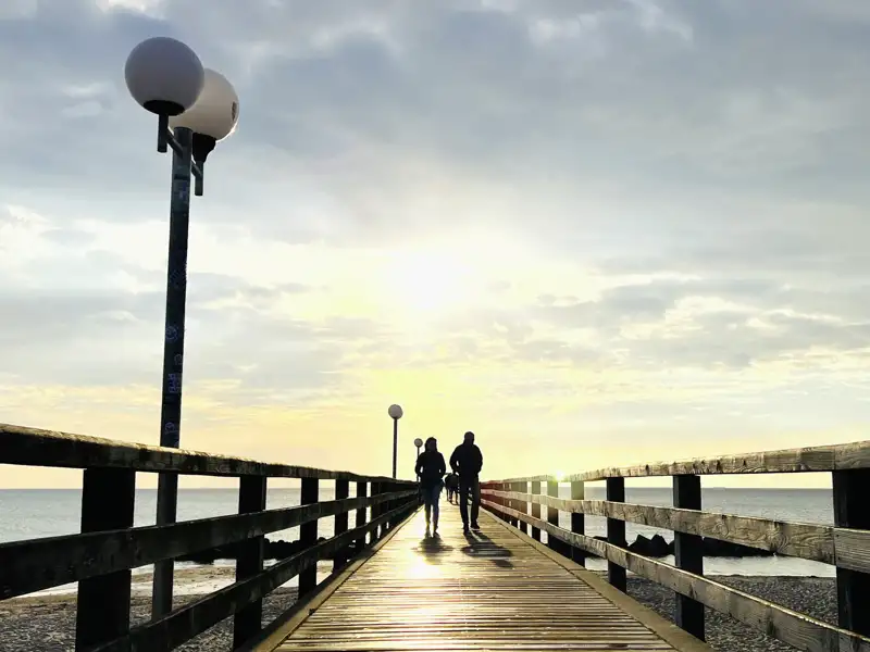 Auf unserer Gruppenreise mit Studiosus spazieren wir über eine Seebrücke bei Sonnenuntergang, an der Ostsee