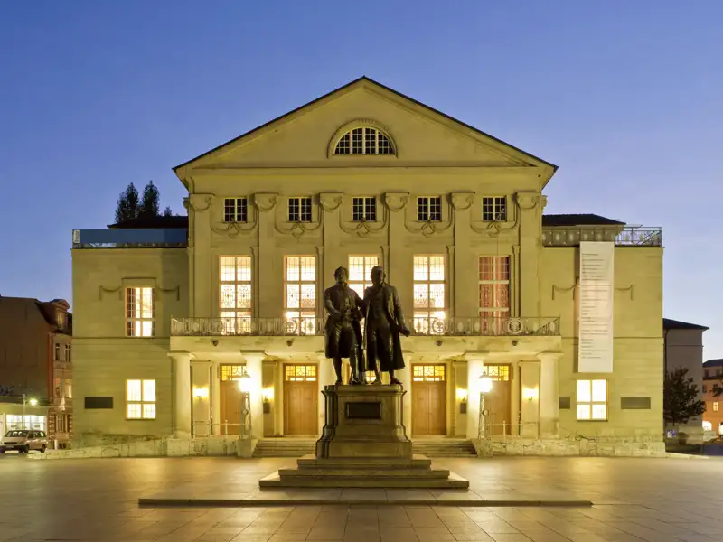 Auf unserer Gruppenreise mit Studiosus besichtigen wir das Deutsche Nationaltheater in Weimar, mit dem beleuchteten Goethe-Schiller-Denkmal im Vordergrund.