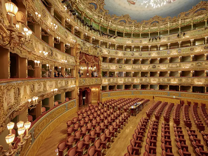 Auf unserer Gruppenreise mit Studiosus  erleben wir den opulenten Innenraum des Teatro La Fenice in Venedig. Ein Highlight der Eventreise sind die goldverzierten Logenränge und die roten Sitze des Opernhauses.