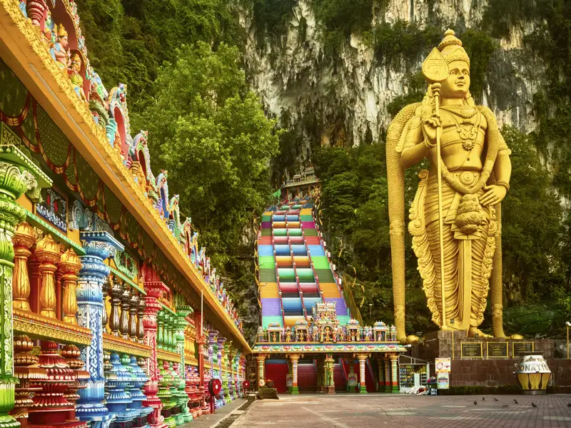 Auf unserer Gruppenreise mit Studiosus besuchen wir die Batu Caves in Malaysia mit der großen, goldenen Statue von Lord Murugan und der langen, bunten Treppe, die zu den Höhlentempeln führt. Ein Highlight jeder Rundreise durch Malaysia.