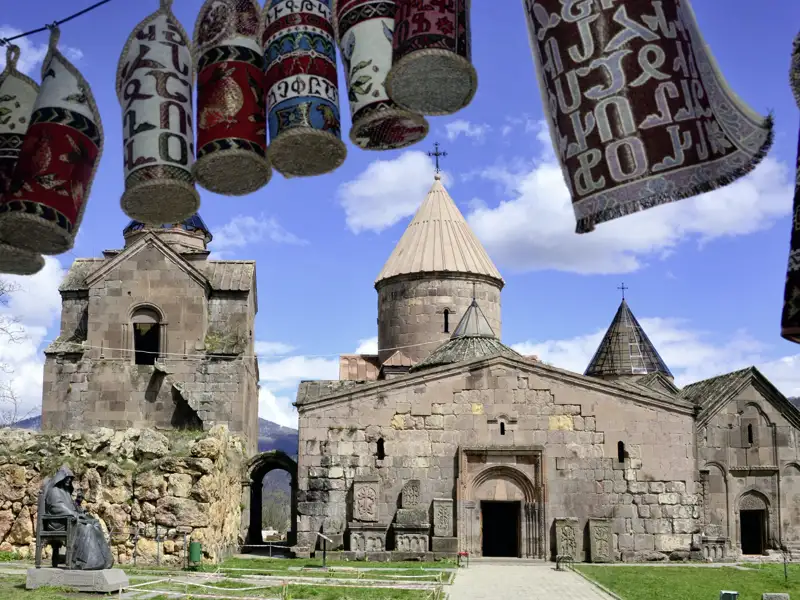 Blick auf das Kloster Goschawank in Armenien, das wor aif dieser Reise besichtigen, mit der Steinfassade und den charakteristischen Dächern unter blauem Himmel.