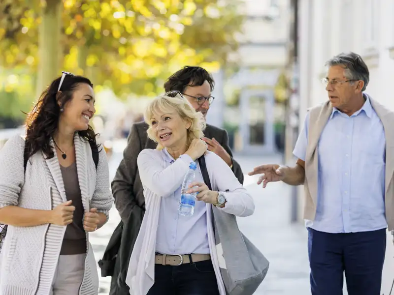 Eine kleine Gruppe von Reisenden bei einer Stadtführung, die von einer Reiseleitung begleitet wird, wie es typisch für Gruppenreisen mit Studiosus ist.