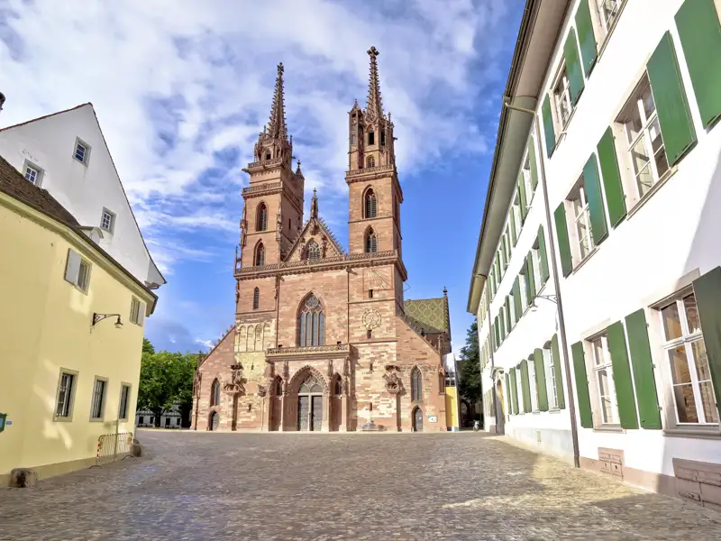 Das gotische Basler Münster aus rotem Sandstein auf dem gepflasterten Münsterplatz während einer Studienreise in der Schweiz.