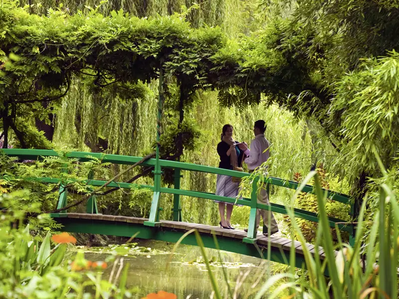 Auf unserer Rundreise mit Studiosus sehen wir ein Paar, dass auf der Japanischen Brücke in Monets Garten in der Normandie steht