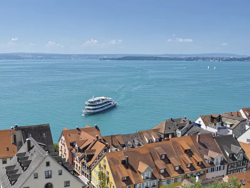 Ausblick einer Eventreise: Ein weißes Ausflugsschiff fährt auf dem Bodensee vor der malerischen Altstadt von Meersburg, ein Highlight unserer Studiosus Rundreise