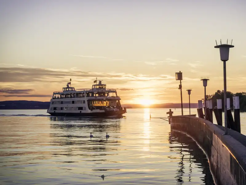 Passagierschiff mit Reisegästen auf dem Bodensee bei Sonnenuntergang auf dem Weg zur Seebühne in Bregenz, ein Highlight unserer Studiosus Gruppenreise.