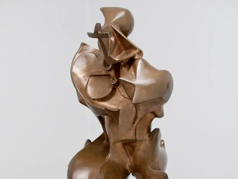 Auf unserer Rundreise mit Studiosus durch Italien endecken wir eine dynamische, futuristische Bronzeskulptur einer schreitenden Figur, ausgestellt vor einer weißen Wand im Museo del Novecento Mailand.