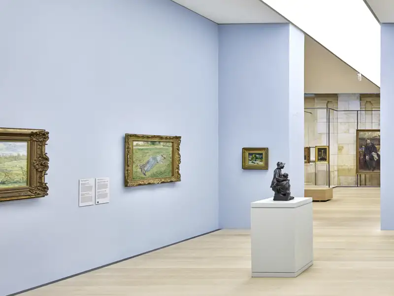 Heller, moderner Ausstellungsraum der Kunsthalle Bremen mit Gemälden in Goldrahmen an der Wand und einer Skulptur auf einem Sockel, ein Highlight jeder Studiosus Gruppenreise.