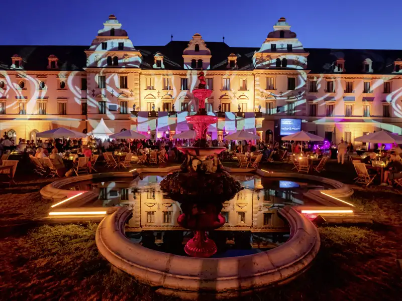 Abendliche Operngala im Innenhof des Fürstlichen Schlosses St. Emmeram mit beleuchtetem Brunnen in Regensburg, ein schöner Anblick während unserer Eventreise mit Studiosus.
