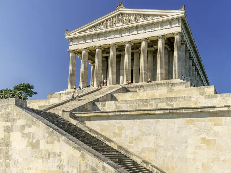 Die imposante Ruhmeshalle Walhalla über dem Donautal mit Besuchern auf der großen Steintreppe bei Sonnenschein, ein Highlight unserer Studiosus Gruppenreise nach Regensburg
