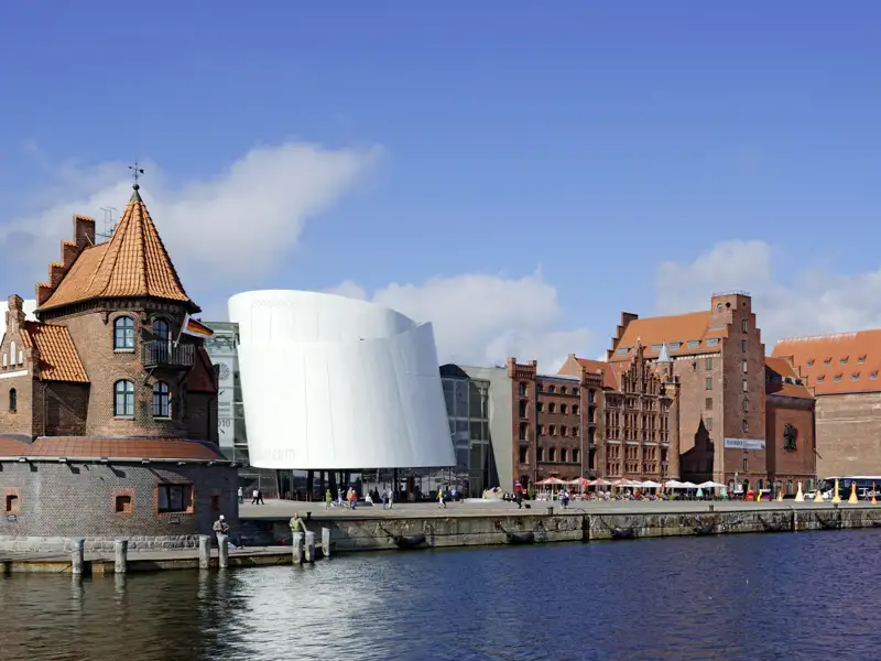 Auf unserer Gruppenreise mit Studiosus führt uns unser Spaziergang durch die alte Hansestadt Stralsund, unser Standort für mehrere Nächte. Tradition und Moderne treffen am Hafen aufeinander, wo sich der futuristische Bau des Ozeaneums in die alte hanseatische Architektur eingliedert.