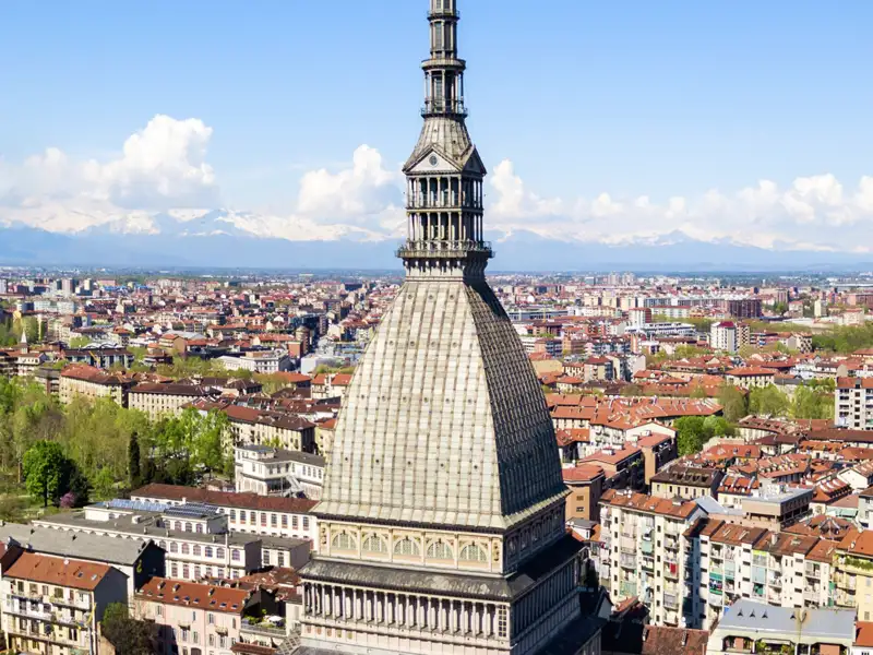 Panoramablick auf Turin mit der markanten Kuppel der Mole Antonelliana vor der Kulisse der schneebedeckten Alpen, ein Highlight unserer Italien-Gruppenreise mit Studiosus.