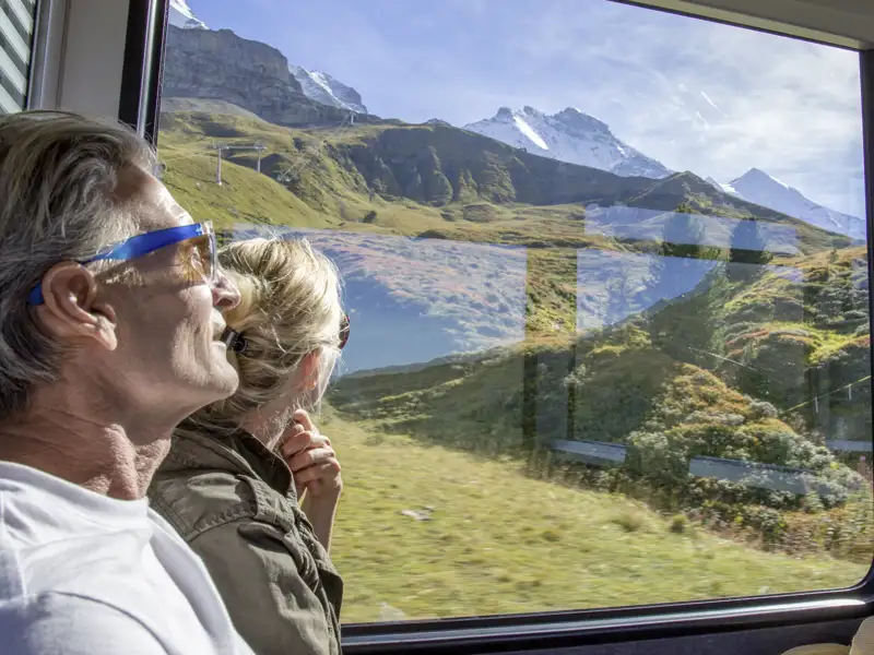 Die Schweiz lässt sich entspannt mit der Bahn bereisen - so wie wir das auf unserer Studienreise machen und Berge und Almen am Zugfenster vorbeiziehen lassen.