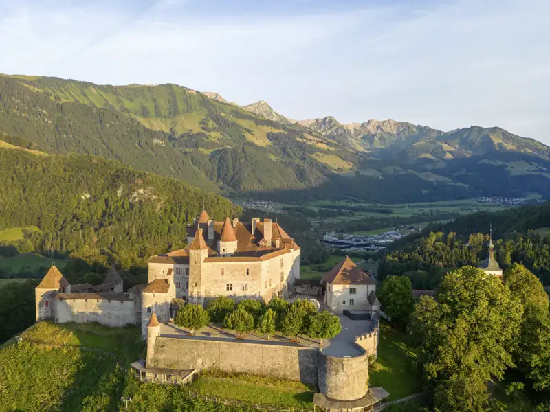 Das mittelalterliche Schloss Gruyères thront auf einem Hügel vor der beeindruckenden Bergkulisse der Freiburger Voralpen, ein Highlight unserer Gruppenreise mit Studiosus.