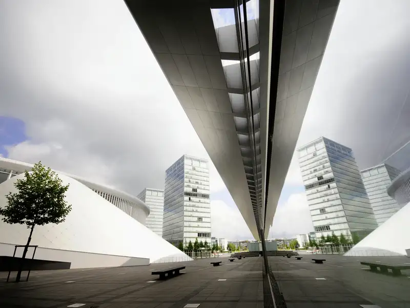 Moderne Architektur in Luxemburgs Europaviertel: Die Philharmonie und Glastürme spiegeln sich in einer Fassade, ein Highlight unserer Rundreise mit Studiosus.
