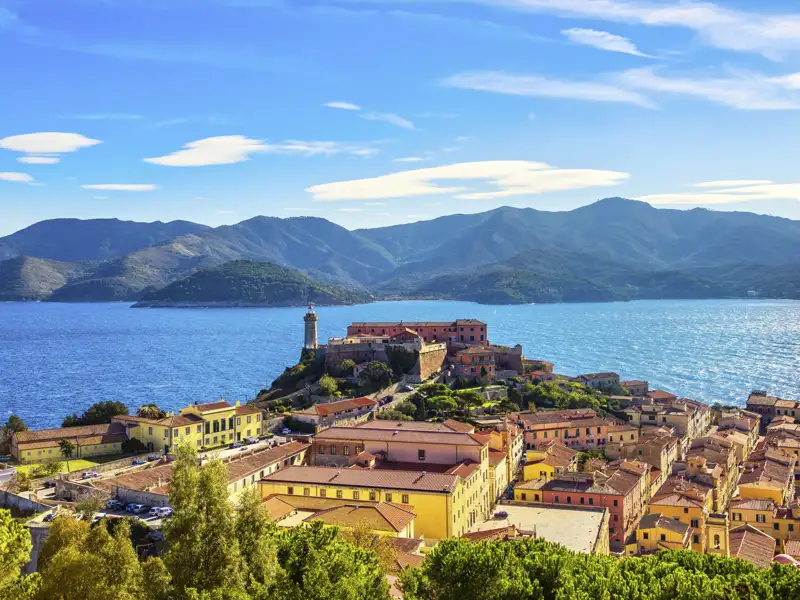 Malerischer Blick über die Altstadt von Portoferraio auf das Forte Stella mit Leuchtturm vor der Bergkulisse Elbas, ein Highlight auf unserer Rundreise mit Studiosus.