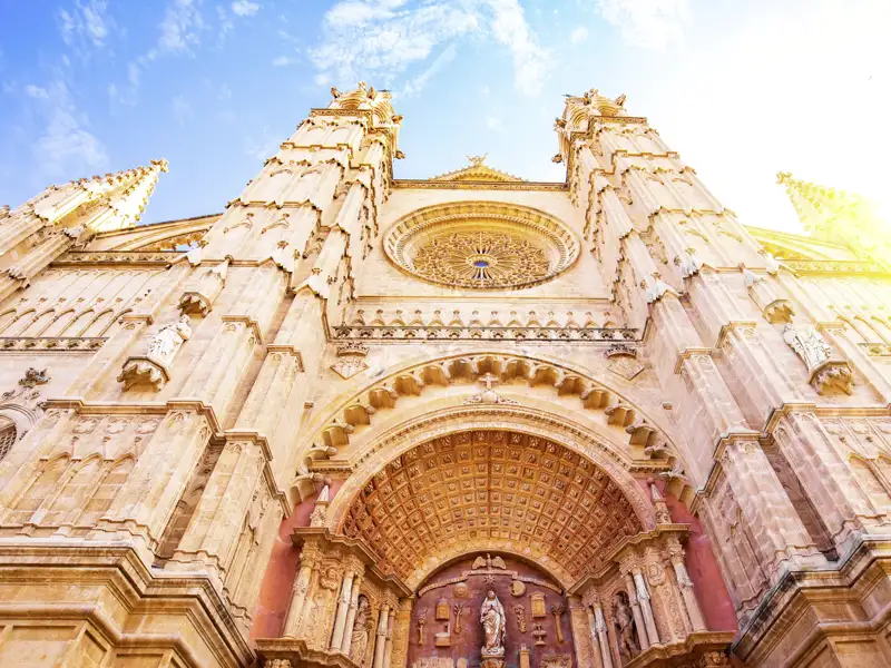 Die prachtvolle gotische Fassade der Kathedrale von Palma de Mallorca mit Rosette, von unten gegen den sonnigen Himmel, ein toller Anblick auf unserer Gruppenreise mit Studiosus.
