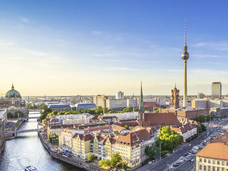 Weitblick über das Zentrum von Berlin mit dem Berliner Dom, der Spree und dem Fernsehturm im warmen Abendlicht, ein Ausblick, den wir auf der Gruppenreise mit Studiosus genießen.