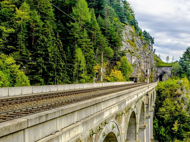 Auf einer Gruppenreise mit Studiosus sehen wir das historische Viadukt der Semmeringbahn, UNESCO-Welterbe,welches durch die grüne Berglandschaft der österreichischen Alpen führt.