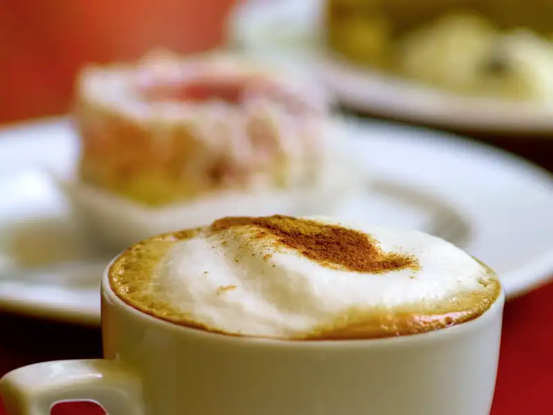 Eine Tasse Melange in einem traditiosreichen Kaffeehaus genießen.
