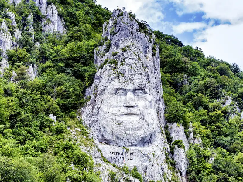 Die kolossale Felsenskulptur des Dakerkönigs Decebalus, gehauen in eine bewaldete Klippe am Eisernen Tor der Donau, bewundern wir auf unserer Gruppenreise mit Studiosus.