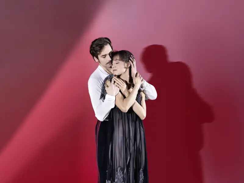 Zwei Tänzer des Stuttgarter Balletts in einer emotionalen Umarmung während der Aufführung von Crankos 'Onegin', ein Highlight auf unserer Eventreise mit Studiosus.