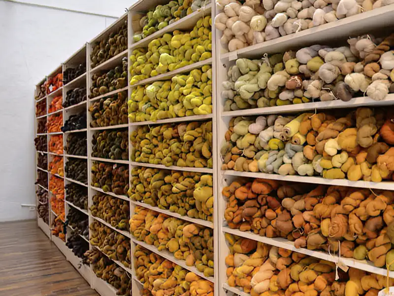 Bunt gefärbte Wollgarne für die Tapisserie-Herstellung lagern in den hohen Regalen einer Manufaktur in Aubusson, dies bewundern wir auf un serer Eventreise mit Studiosus.