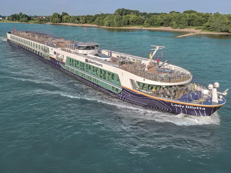 Das moderne Flusskreuzfahrtschiff Lady Diletta gleitet während einer Studienreise bei Sonnenschein auf dem Rhein.